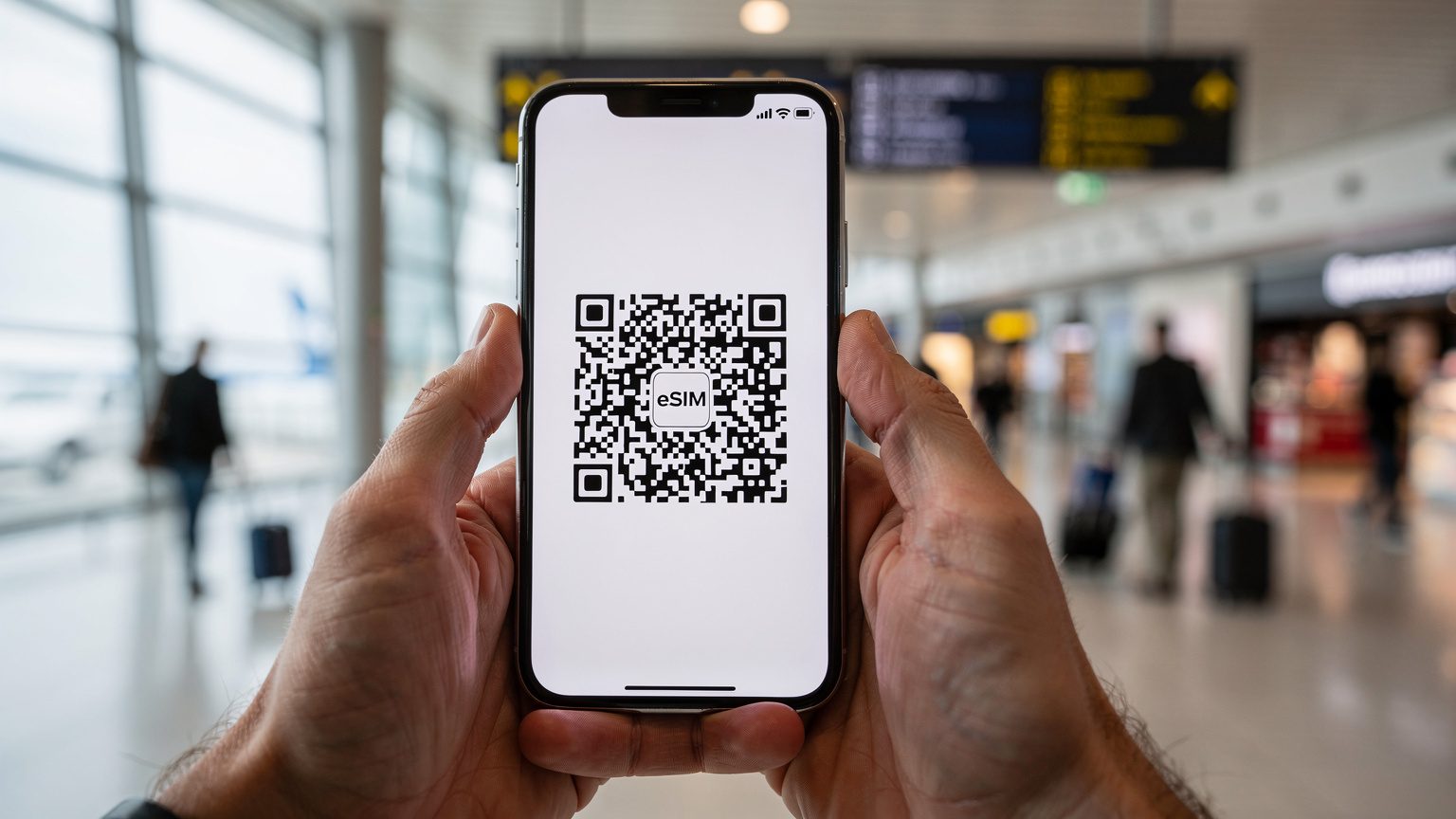 Un primo piano di mani che tengono uno smartphone con un codice QR per l'attivazione di un'eSIM, mentre sullo sfondo, sfocato, si intravede un terminal aeroportuale affollato.