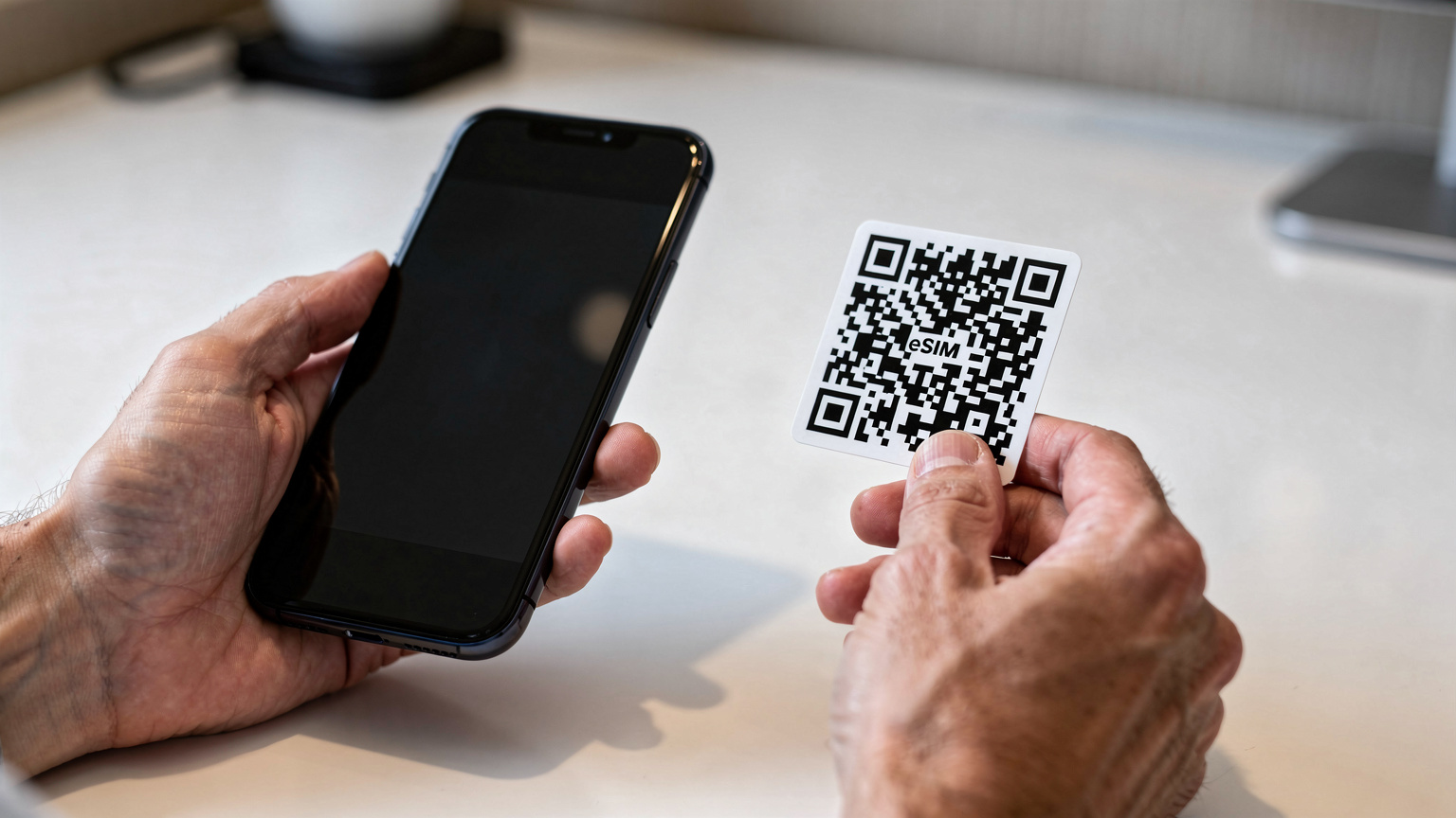 Due mani adulte tengono uno smartphone moderno, mostrando il processo di scansione di un codice QR su un altro schermo per attivare un'eSIM, con un'interfaccia pulita e focalizzata.