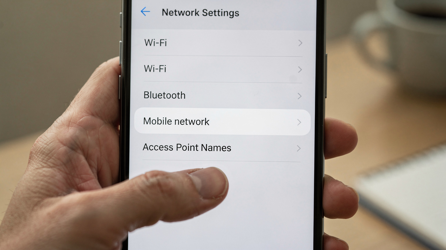 Un gros plan sur un écran de smartphone affichant les paramètres réseau, avec l'option 'APN' en surbrillance, démontrant la configuration manuelle nécessaire de l'eSIM.