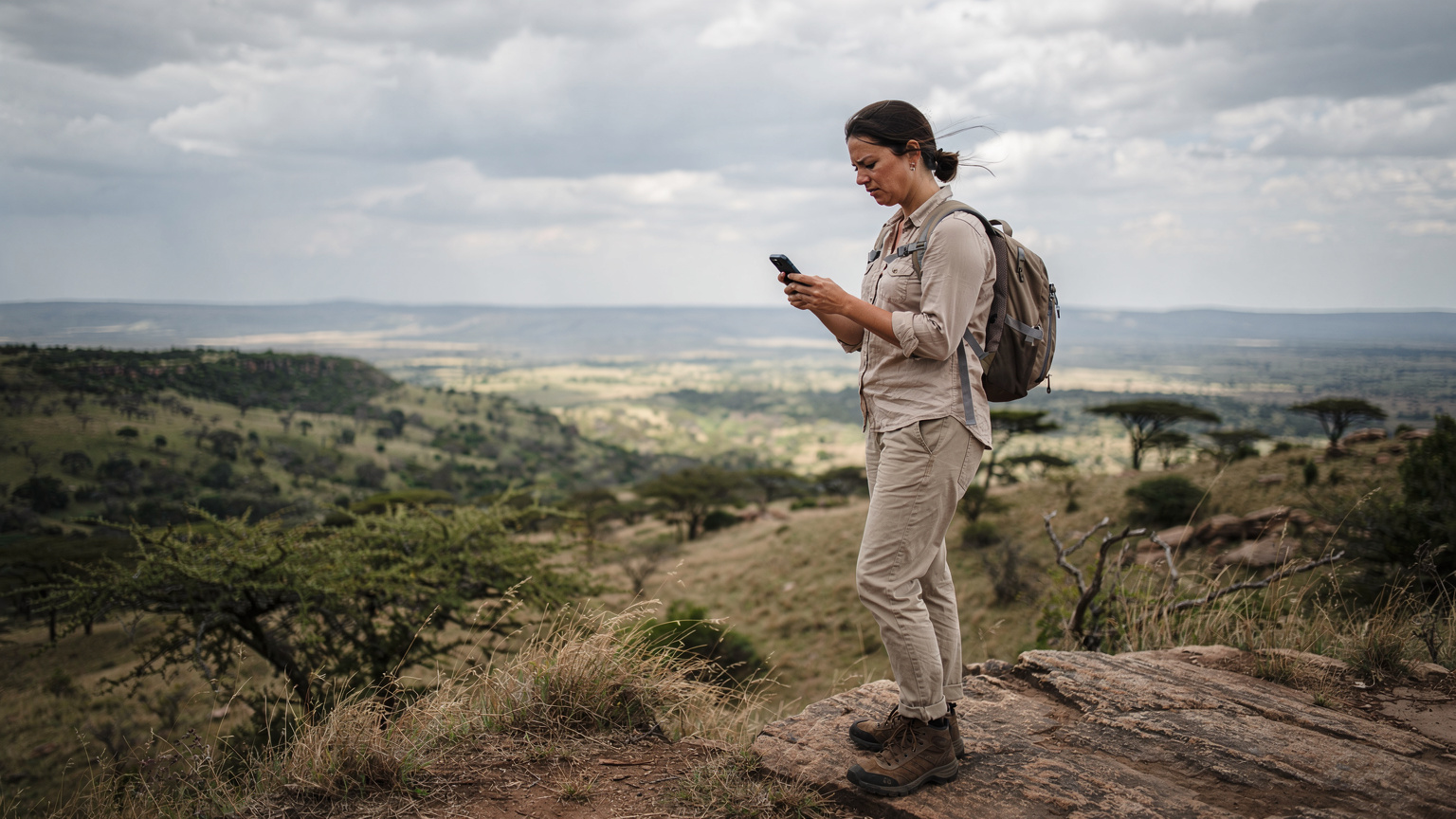 En reisende sjekker telefonen sin for signal i et naturskjønt, men avsidesliggende område av Tanzania.